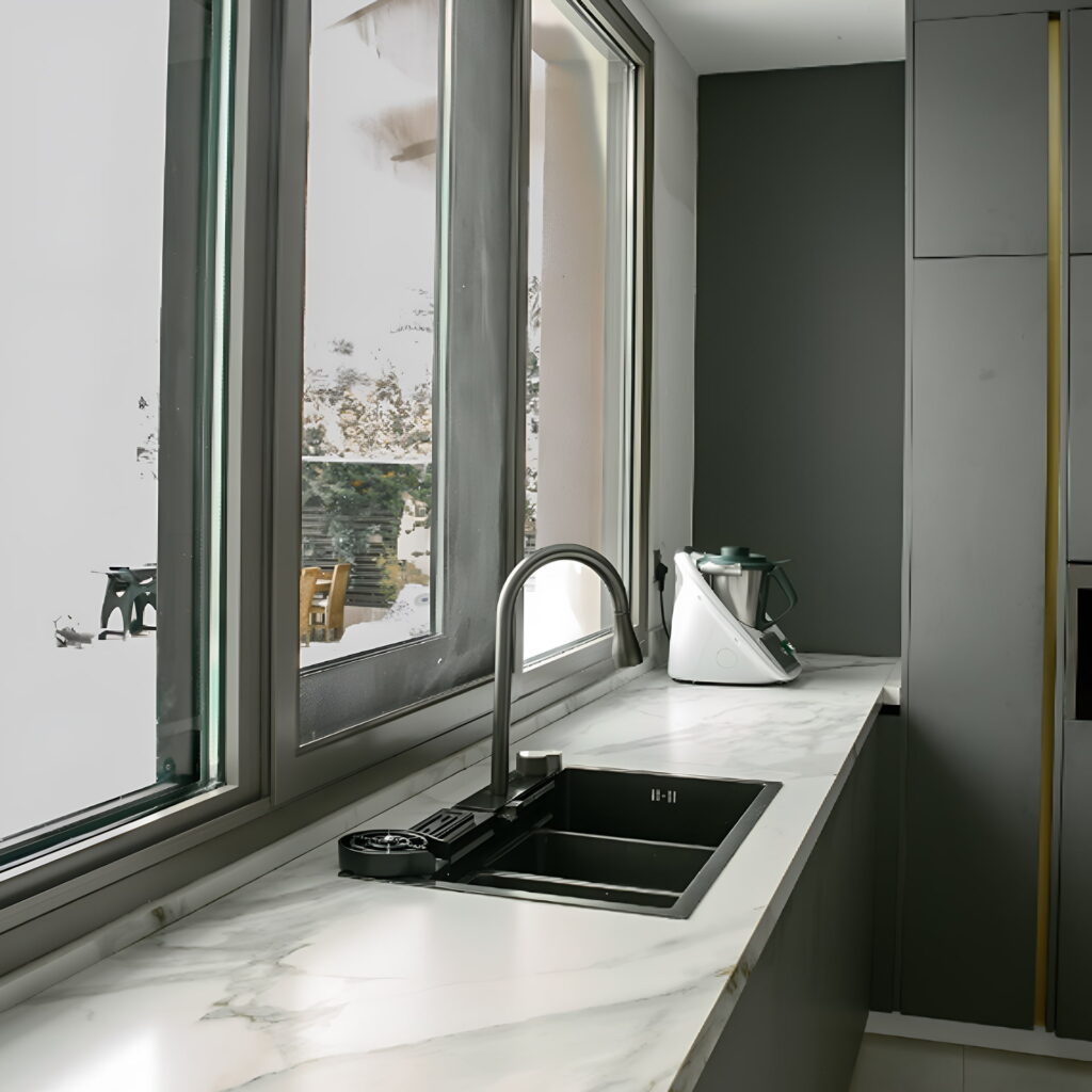 Luxury marble countertop with built-in sink and large window in a modern Dubai kitchen by Rawaa Interiors